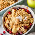 Quick Cranberry Apple Crisp Delicious Quick Cranberry Apple Crisp recipe with step-by-step instructions. Print Recipe Pin Recipe Prep Time 18minutes mins Cook Time 37minutes mins Total Time 55minutes mins Servings 6 servings Calories 1925 kcal Ingredients For the filling: 2 tbsp all-purpose flour (I use King Arthur all-purpose flour) 1/2 tsp ground ginger (freshly ground preferred) 2 cups chopped apples (about 3-4 medium apples, peeled and diced into 1/2-inch pieces) 3 cups cranberries (fresh or frozen) 1 cup light brown sugar 1 tsp vanilla (pure vanilla extract for best flavor) For the topping: 1/2 tsp ground cinnamon 8 tbsp unsalted butter (softened to room temperature) 1/2 cup light brown sugar (packed) 1/4 tsp ground ginger 1 pinch salt 3/4 cup all-purpose flour 1/2 cup rolled oats (old-fashioned, not instant) 1/4 tsp ground nutmeg For serving (optional): vanilla ice cream (optional but recommended for serving) Instructions Preheat your oven to 350°F and lightly grease a 9x13-inch baking dish with butter or cooking spray. While the oven heats, prepare your mise en place by peeling, coring, and dicing the apples into roughly 1/2-inch pieces—I like to toss them in a bit of lemon juice if you have it on hand to prevent browning, though it's not essential. Measure out all your dry ingredients for both the filling and topping so everything is ready when you need it. In a large bowl, combine the prepared apples with the cranberries (fresh or frozen—no need to thaw), then add 1 cup light brown sugar, 2 tablespoons all-purpose flour, 1 teaspoon vanilla extract, and 1/2 teaspoon ground ginger. Gently toss until the fruit is evenly coated with the sugar and spices. Transfer this mixture to your prepared baking dish, spreading it in an even layer. The flour will help thicken the juices as the fruit bakes, creating a lovely sauce beneath the crisp topping. In a separate bowl, combine the softened butter with 1/2 cup packed light brown sugar, 3/4 cup all-purpose flour, 1/2 tsp ground cinnamon, 1/4 tsp ground ginger, 1/4 tsp ground nutmeg, and a pinch of salt. Using a fork or your fingertips, work the mixture together until it resembles coarse breadcrumbs with pea-sized pieces of butter visible throughout—I find using my fingertips gives the best texture for a truly crispy topping. Once you reach this texture, add the 1/2 cup old-fashioned rolled oats and stir gently until just combined, being careful not to overwork the mixture. Spread the crisp topping evenly over the fruit filling from Step 2, then gently press it down with the back of a spoon or your fingers to create an even, compact layer. This helps the topping bake more uniformly and achieve that satisfying crispness. Bake in the preheated 350°F oven for 35-40 minutes, until the topping is golden brown and you can see the fruit starting to bubble slightly at the edges of the dish.